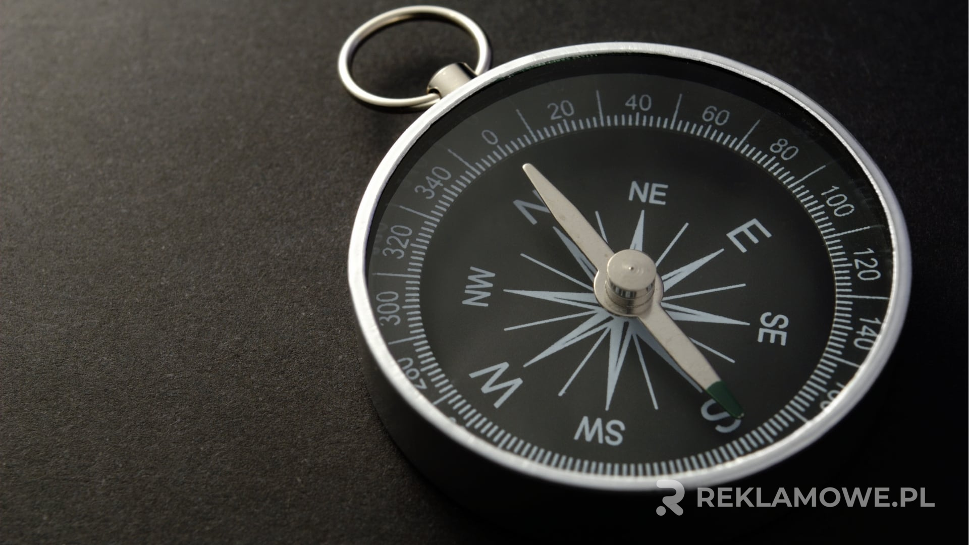 Kompas na mapie z notesem i długopisem symbolizujący projektowanie reklam